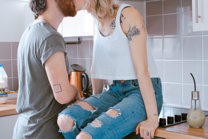A man kissing a woman in the kitchen