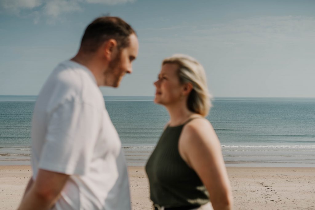 A man and a woman standing on a beach